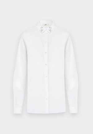 Camicia bianca a maniche lunghe con colletto a punta, arricchita da decorazioni in paillettes argentate su entrambi i lati.