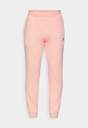 Lyserøde sweatpants lavet af blødt stof, med en ribbet talje og manchetter, samt et lille sort Puma-logo på venstre lår.