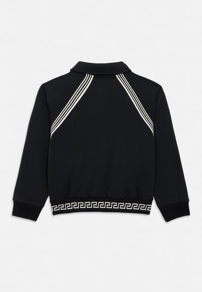 Must pikkade varrukatega jakk, millel on õlgadel valged kolmiktriibud ja alumisel äärel valge geomeetriline muster.