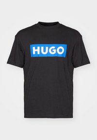 Zwarte katoenen t-shirt met een blauw rechthoekig logo met de tekst "HUGO" in wit, ronde halslijn en korte mouwen.
