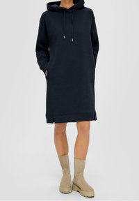 Mörkblå hoodie-kjol i bomullsblandning, med en framficka av kangaroo-stil, ribbade muddar och sidoklyftor vid fållen.