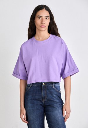 Short purple cropped t-shirt with short sleeves and a round neckline, paired with dark blue jeans. Fabric appears soft and smooth.