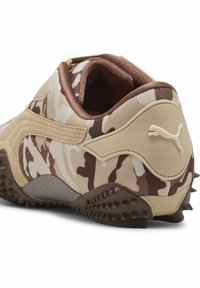 Bruine camouflage sportieve schoen met bovenwerk van stof, gewatteerde kraag en gemodelleerde rubberen buitenzool met een gestructureerde grip, benadrukt door een logo.