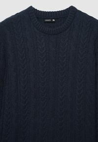 Maglione navy a trecce con scollatura rotonda a costine, caratterizzato da una consistenza spessa e filati grossi. L'etichetta della taglia indica XL.