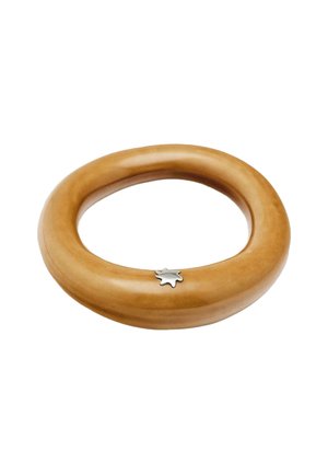 Anneau en bois lisse et rond avec un petit pendentif en forme de feuille en argent attaché d'un côté, sur fond blanc.