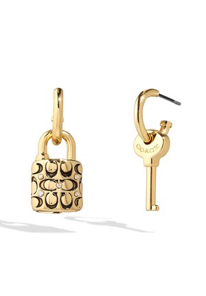 Pendientes en tono dorado, uno con forma de candado con detalles negros y cristales, el otro con forma de llave grabada con "Coach."