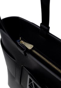 Borsa a spalla nera in pelle con texture liscia, hardware della cerniera in oro, tasca interna e dettaglio del logo sul davanti. Design con apertura superiore.