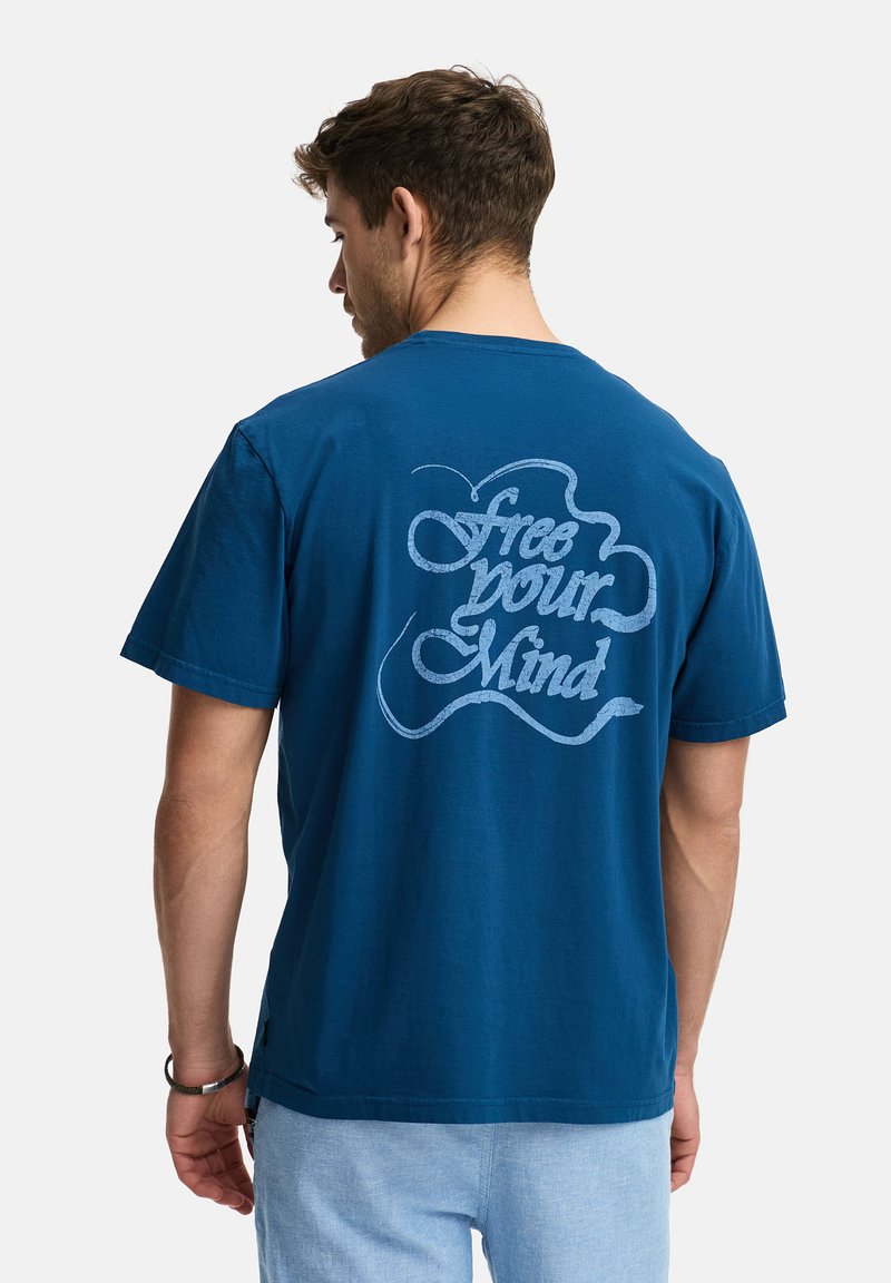 Camiseta de algodón azul marino con un gran gráfico de texto en azul claro en la espalda que dice "libera tu mente". Mangas cortas, diseño de cuello redondo.
