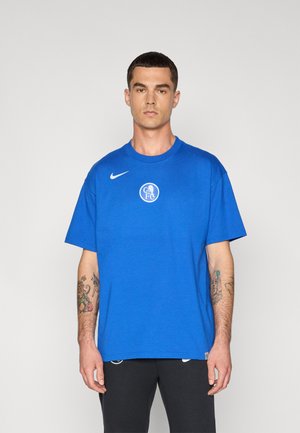 Zils kokvilnas T-krekls ar apaļu kakla izgriezumu, īsām piedurknēm un baltu apļa logotipu krūtīs. Iezīmēts ar baltu Nike ķīļveida logotipu.