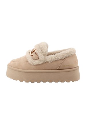 Mocassino beige con plateau, suola spessa e testurizzata, fodera in pelliccia soffice intorno al colletto e alla parte superiore, con fibbia decorativa metallica sulla parte frontale.