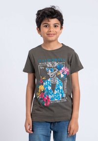 T-shirt en coton vert foncé avec un imprimé graphique d'un squelette portant des lunettes de soleil, entouré de fleurs, avec le texte "California Beach Party".