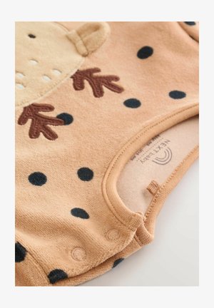 Body pentru bebeluși, de culoare piersică, cu buline negre, având un design cu fața unui urs, labe brodate de culoare maro și închideri cu capse în partea de jos. Textură moale.