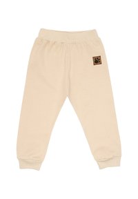 Beżowe spodnie dresowe dla dzieci z elastycznym pasem i ściągaczami, z małą brązową naszywką z czarnym śladem łapy na prawym boku.