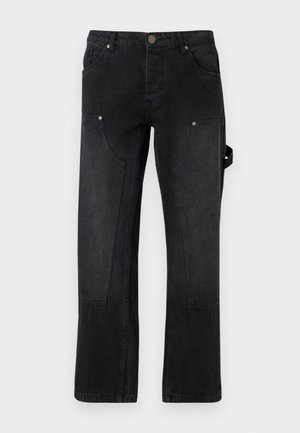 Pantalons en denim noir à coupe droite, avec deux poches avant, des coutures visibles et un détail de sangle sur le côté.