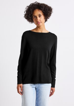 Sort langærmet sweater lavet af glat, blødt materiale med en bred halsudskæring og ribbede manchetter. Sammen med lyseblå jeans.