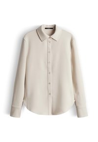 Blusa beige a maniche lunghe con collo classico, chiusura con bottoni sul davanti e orlo curvo. Il tessuto appare liscio con una leggera lucentezza.