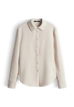 Beige blouse met lange mouwen, een klassieke kraag, knoopsluiting aan de voorkant en een afgeronde zoom. De stof lijkt glad en heeft een lichte glans.