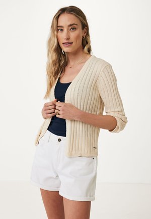 Cremfarbener gerippter Cardigan mit V-Ausschnitt, drei Viertelärmel und lockerer Passform, getragen über einem marineblauen Top und weißen Shorts.