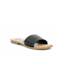 Zwarte leren slipper met een brede band, platte zool en tan kleurige binnenzool. Contraststeek langs de rand voegt detail toe.