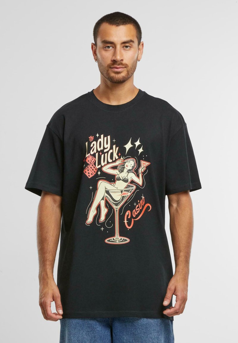 Tricou negru din bumbac cu un grafic retro colorat reprezentând o femeie cu un cocktail. Mâneci scurte, croială lejeră și gât rotund.