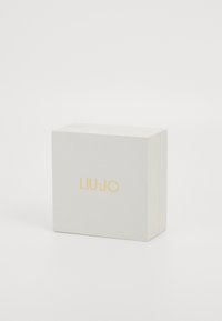 Hvit rektangulær boks med en teksturert overflate, med en gull "LIU·JO"-logo på fronten, designet for emballasje.