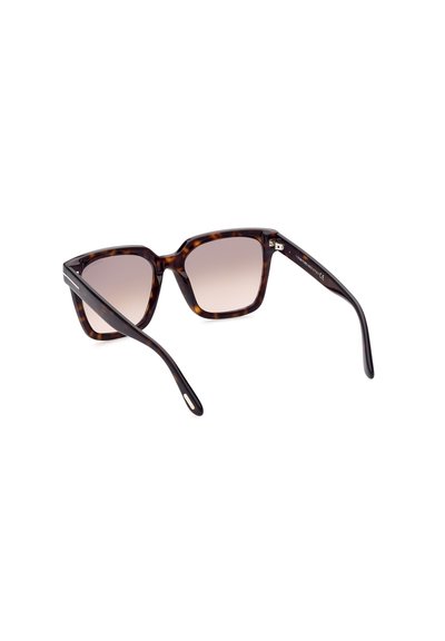 Lunettes de soleil en écaille de tortue avec des verres dégradés. Forme carrée, branches larges et détail en métal sur le côté. Texture lisse.