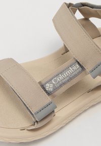 Bežne sandale s smešnim trakama, s tekstilnim gornjim dijelom, prilagodljivim čičak zatvaranjem i podlogom od pjenaste mase. Vidljiv Columbia brand.