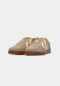 Light brown suede sneakers with cream stripes, round toes, and textured rubber soles. Features laces and a padded collar for comfort.