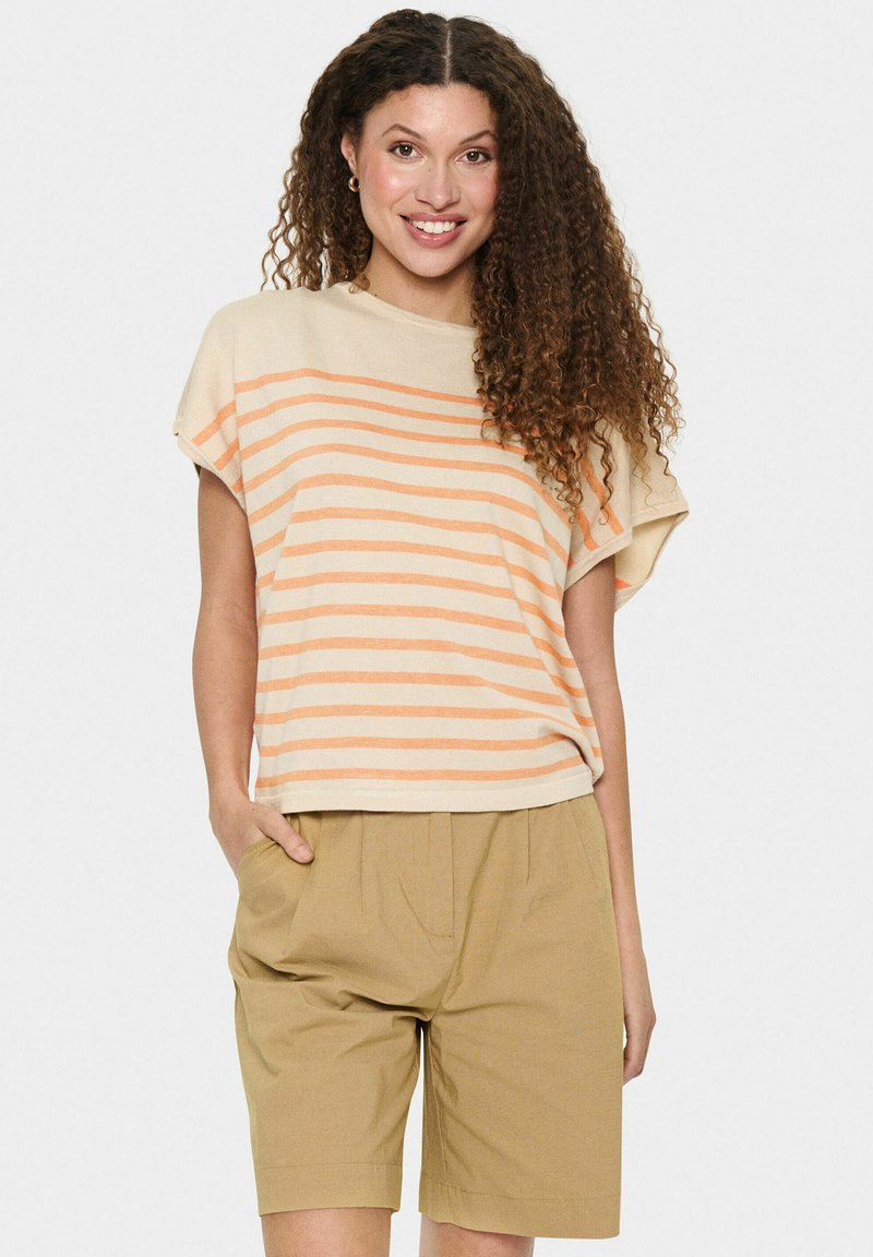 Beige gestreepte shirt met oranje horizontale lijnen en een losse pasvorm, gecombineerd met beige shorts. Zachte stof en een ontspannen ontwerp.