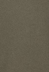 Tela texturizada en verde oliva con un patrón entrelazado. La superficie parece áspera y duradera, adecuada para tapicería o decoración.