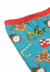 Colorful blue fabric featuring gingerbread men, candy canes, and ornaments, accented by a red waistband. Material appears soft and lightweight.
