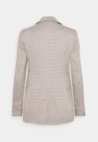 Blazer beige tailleur avec un motif à carreaux noir et rouge, manches longues et détail de fente au dos, présenté sur un fond blanc uni.