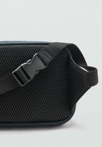 Borsa a tracolla nera in rete con superficie testurizzata, dotata di una robusta tracolla regolabile e una chiusura in plastica elegante.