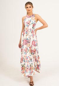 Kwiatowa sukienka maxi z wysokim dekoltem, wykonana z lekkiego materiału. Posiada białe tło z różowymi i niebieskimi kwiatami oraz falbanistym dołem.
