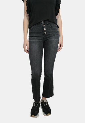 Jeans in denim grigio scuro con vita alta, cinque tasche, chiusura a bottone e design a gamba svasata. Abbinati a sneakers nere.