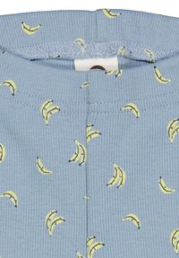 Modrá  žebrovaná látka s opakujícím se vzorem banánů v žluté a černé barvě, s měkkým elastickým pasem nahoře.