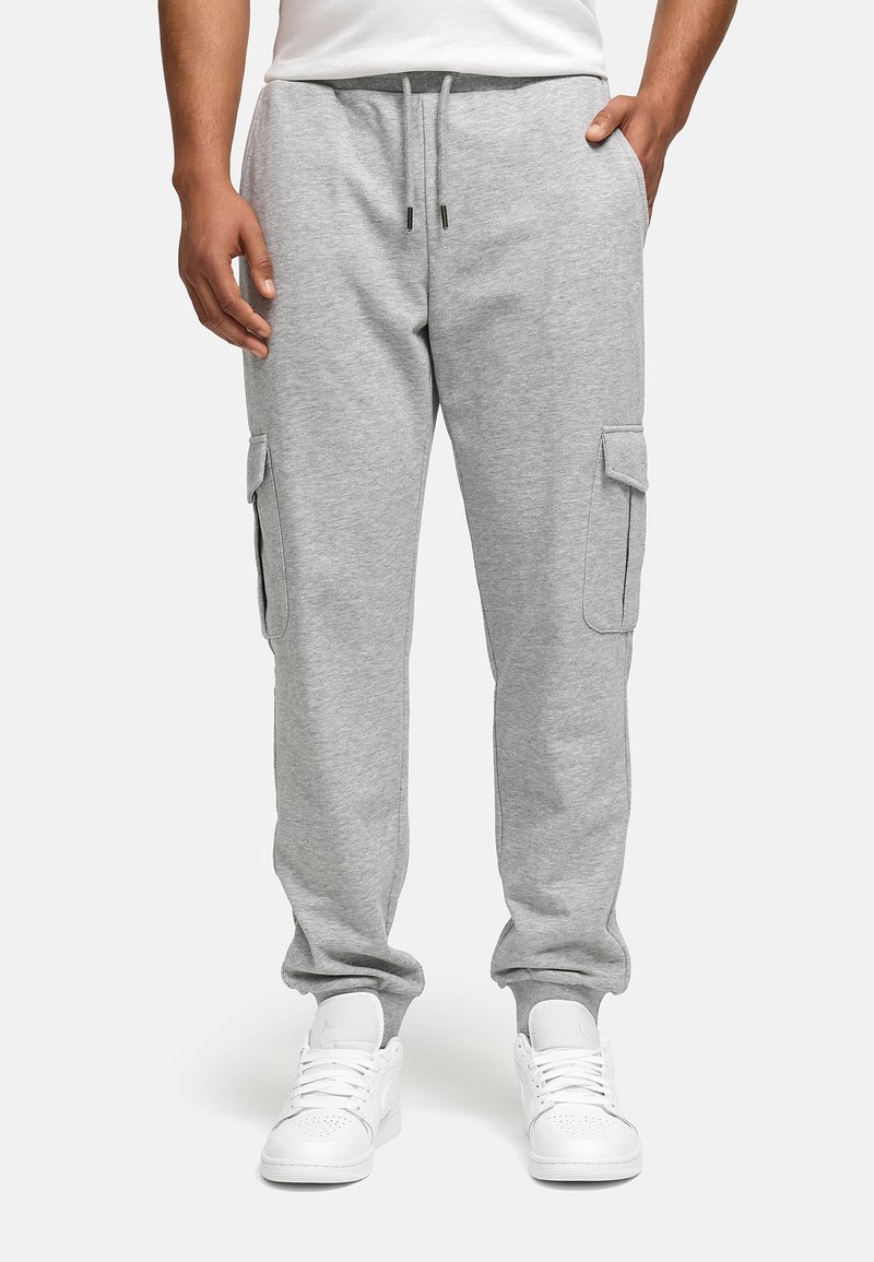 Gray cotton joggers with side cargo pockets, elastic waistband, and cuffs. Paired with white sneakers.