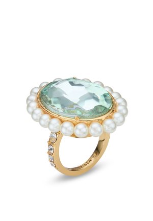 Gouden ring met grote ovale lichtblauwe edelsteen, omringd door witte parels en kleinere heldere kristallen op de band.