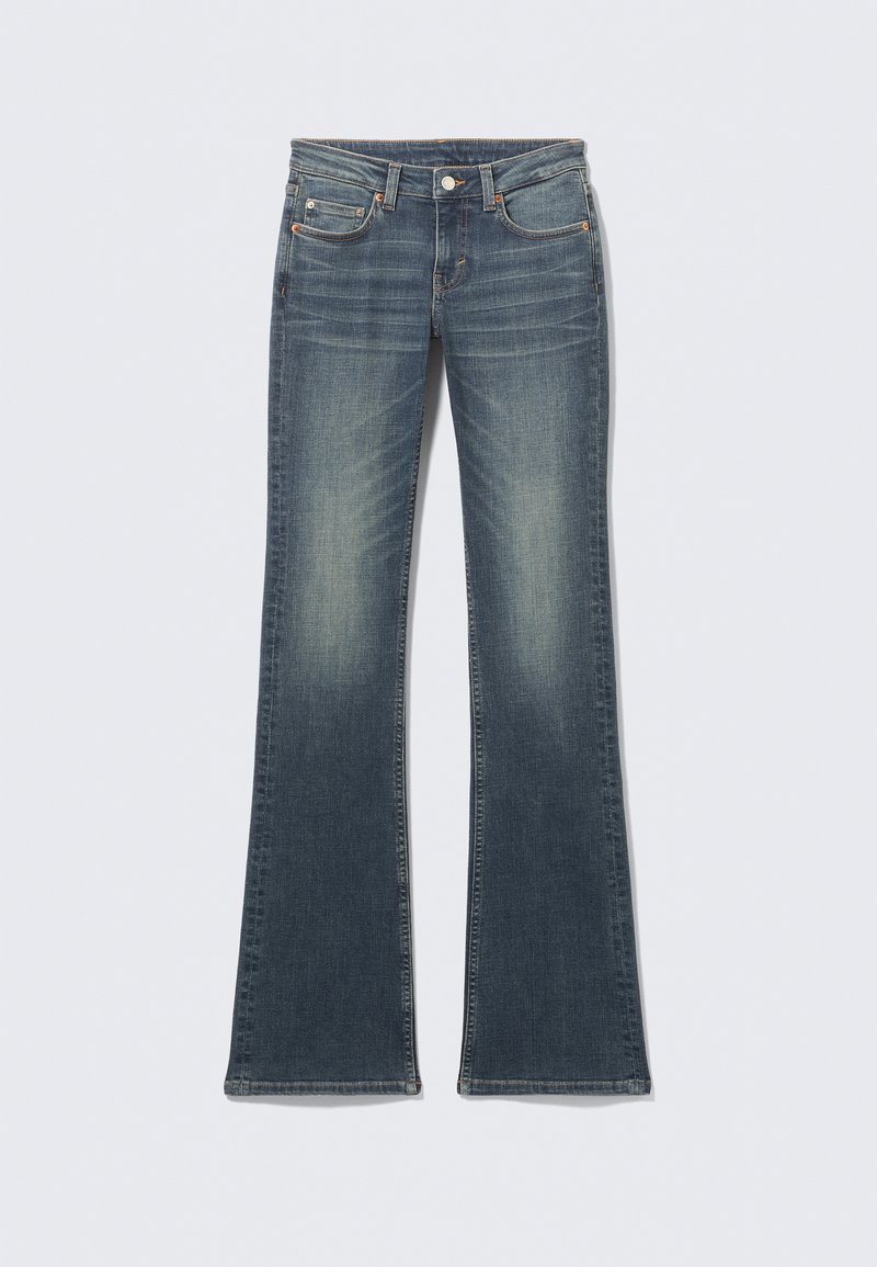 Jean en denim bleu évasé avec une finition délavée, cinq poches, surpiqûres contrastantes et une fermeture à bouton à la taille.