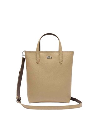 Sac fourre-tout en cuir texturé beige avec deux anses, bandoulière marron réglable et petit logo crocodile argenté sur le devant.