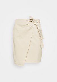 Jupe portefeuille beige en coton, dotée d'un nœud noué à la taille, d'une coupe droite et d'une texture lisse.