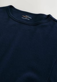 Navy blue cotton t-shirt with a round neckline, flat seams, and label showing "NEXT THERMOGEN." Smooth texture and casual cut.