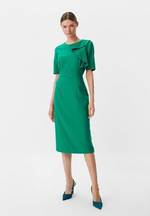Grünes Midikleid mit kurzen Ärmeln, ausgestattet mit einer Rüsche an der linken Schulter. Glatter Stoff mit figurbetonter Silhouette.