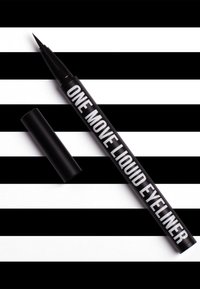 Musta nestemäinen eyeliner-kynä, jossa on ohut kärki. Kynässä on valkoinen teksti "ONE MOVE LIQUID EYELINER" musta-valkoista raidallista taustaa vasten.