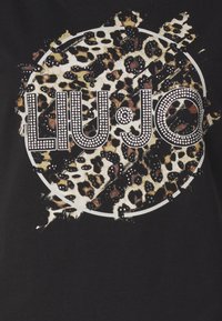 T-shirt nera con grafica a stampa leopardata caratterizzata da accenti di strass e il nome del marchio "LIU·JO" in bold lettere bianche.