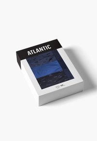 Niebieskie i granatowe kąpielówki wyeksponowane w prostokątnej czarno-białej pudełku oznaczonym "ATLANTIC". Pudełko ma przezroczysty panel z przodu dla lepszej widoczności.