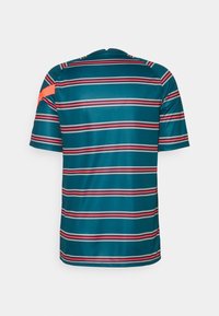 Camisa de manga corta en color verde azulado con rayas horizontales en rosa y blanco. Presenta un escote redondo y un audaz detalle en naranja en el hombro.