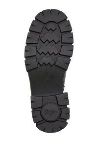 Suela de zapato de goma negra con un patrón de tracción profundo, que presenta diseños en zigzag y en bloques. Superficie texturizada y logo circular en relieve.