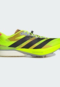 Chaussure de course Adidas pointue jaune-vert vif et noire, avec une semelle "Lightstrike Pro" et des pointes métalliques sur la semelle extérieure pour une utilisation sur piste.
