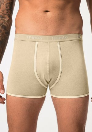 Boxers beiges en coton avec une texture douce, dotés d'une large ceinture élastique étiquetée "JP1880" et de détails de couture contrastants.